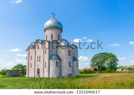 Church of Our Saviour on Nereditsa, Velikiy Novgorod vicinity, Russia. Russian countryside landscape with ancient orthodox temple against blue sky. Architectural landmark, UNESCO world heritage site Royalty-Free Stock Photo #1355040617