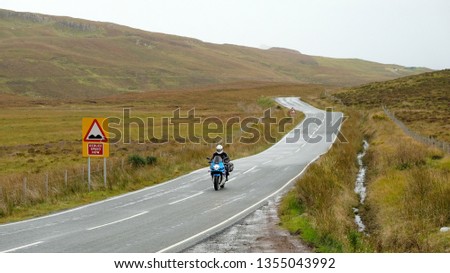 Motorcycle on Country road in rolling hills of Scotland, UK