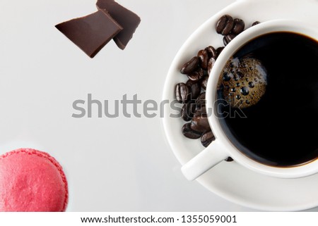 Cookies, coffee beans and cup of coffee on white background