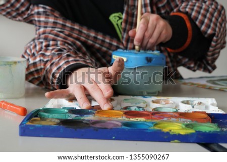 Creative Art Workshop. School kids working with colors. Colors, brush, paper and child hands.