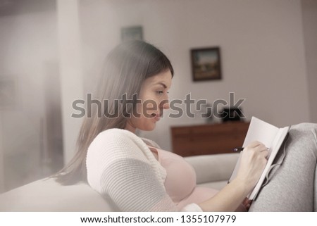 Pregnant woman writing notes.