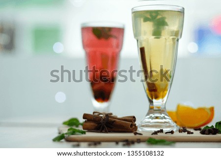 two glasses with colored hot drinks from which steam comes. winter hot seasonal vitamin drinks