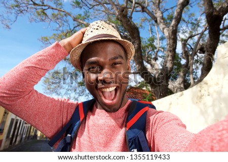 Close up portrait of happy african american travel man taking selfie