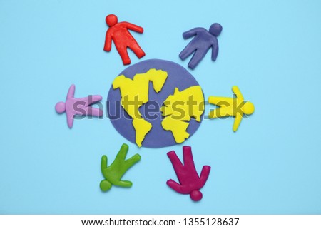 Plasticine figurines of people of different races are on planet earth. A variety of interactions, communication and globalization. Cartoon art.