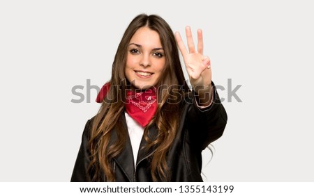 Young woman with leather jacket happy and counting three with fingers over isolated grey background