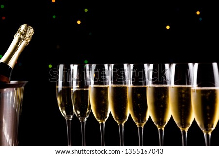 glasses of champagne on black  background with bokeh circles. Place for text.