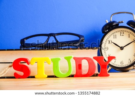 Education concept with books, alarm clock,glass with word STUDY.