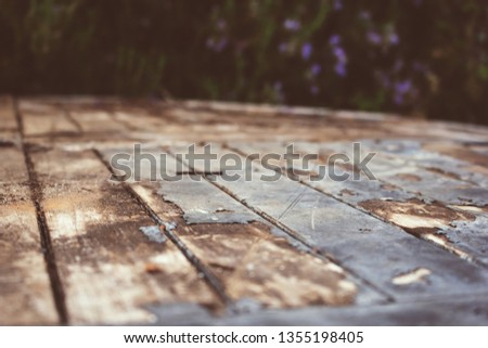 A vintage wooden table on the patio in the shade and in sunshine