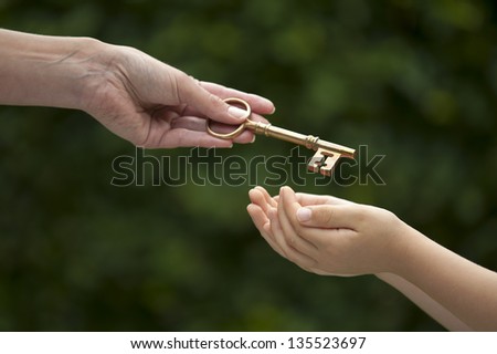 mother handing key to daughter Royalty-Free Stock Photo #135523697