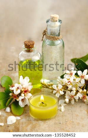 massage oil with and spring flower with candle on board