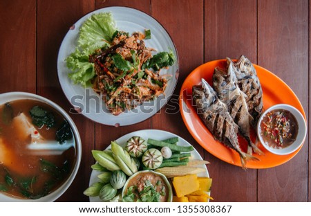 Nam Prik Pla To, fried fish, Spicy fish salad, Tom Yum soup - Thai street food lunch set and fresh vegetables, pumpkin, cucumber, bean and cauliflower