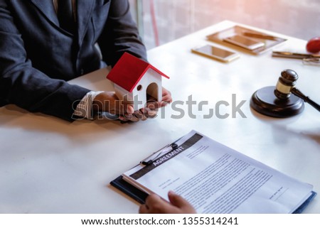 lawyer explain the documents contact of insurance of fire and theft a house at office desk. home protection, family, insurance.rent house concept .