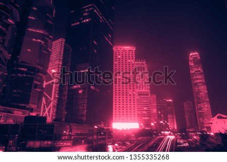 Hong Kong Business District at Night. Corporate building at the back and busy traffic across the main road at rush hour