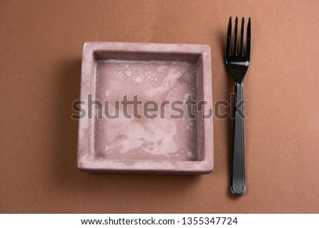 top view fork and empty dish on a brown background