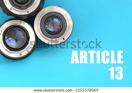 Several photographic lenses and article 13 inscription on blue