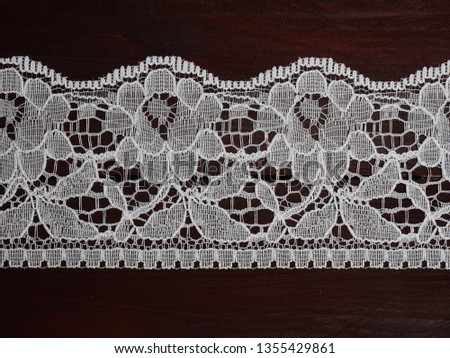 White lace on dark brown wooden background