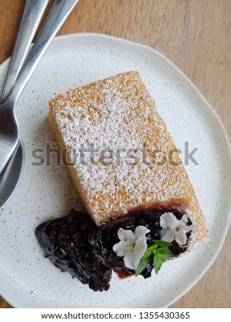 Soft cake with blueberry jam decorative by small cute white flower
