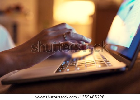 Shallow depth of field of lady typing on a laptop.