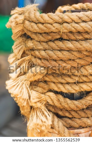 Mooring ropes on the pier. Embankment of the black sea. Thick rope ropes on a metal pole.