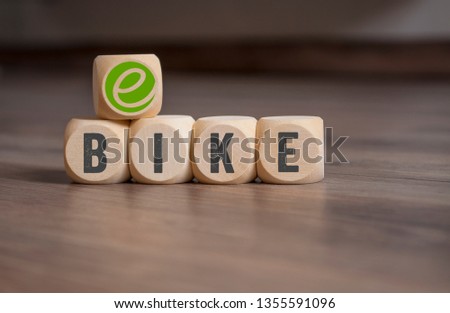 Cubes dice with e-bike on wooden background