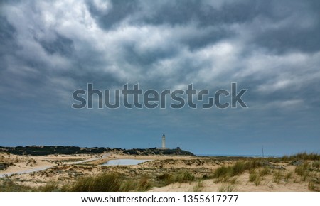Wide angle view of stormy clouds over Trafalgar lighthouse in Cadiz