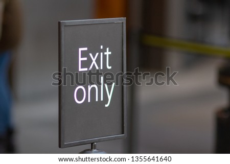 White on grey Exit Only sign shallow depth of field.