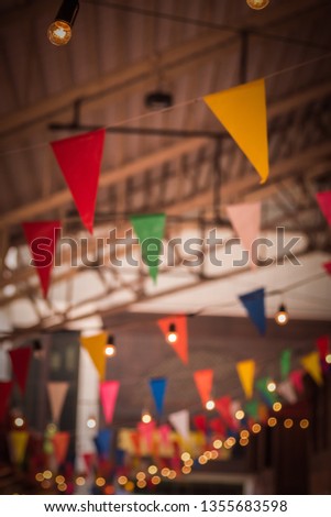 Vintage tone image of Multi-colored flags at festivals with lights decorated on day time.