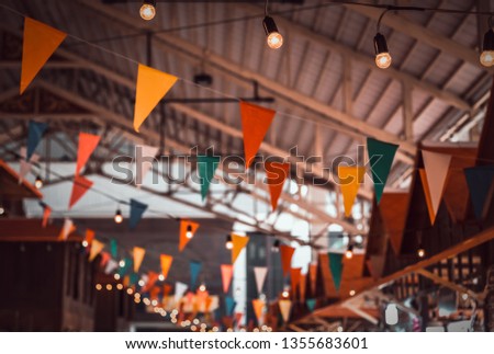Vintage tone image of Multi-colored flags at festivals with lights decorated on day time