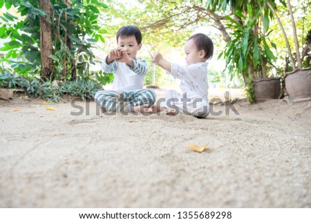 Two children playing on ground in a Summer Day. The concept of learning nature of brother and sister. Selective focus. Copy space.