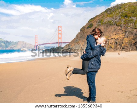 Loving couple man and woman hugging on beach in San Francisco on Golden gate bridge background on Sunny day