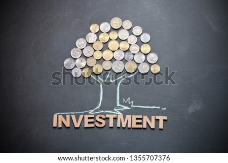 Drawing of a tree with different countries’ currency are with chalk on blackboard. This photo shows economical concept. 