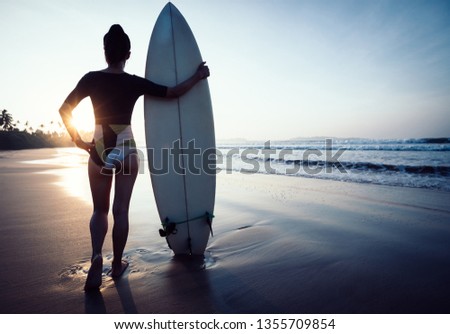 Woman surfer with surfboard ready to surf on a beach