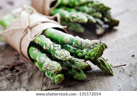 Bunch of fresh asparagus on wooden table Royalty-Free Stock Photo #135572054
