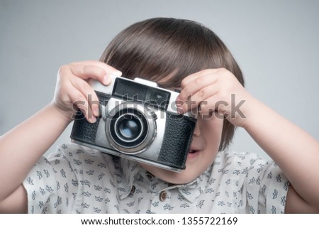 Kid with old photo camera 