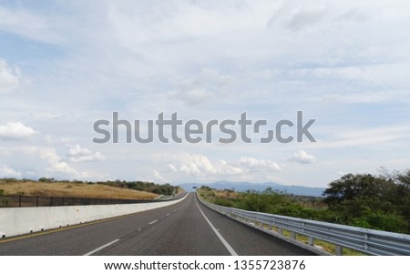View of a straight Highway in Mexico on a cloudy day