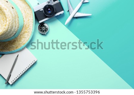 Summer Travel accessories vacation holidays concept on blue and green background copy space with camera airplane hat and notebook for banner and poster