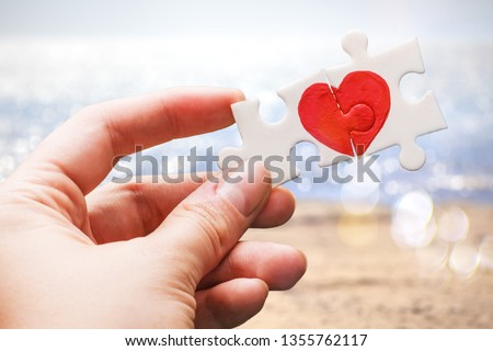 Puzzle pieces with painted red heart