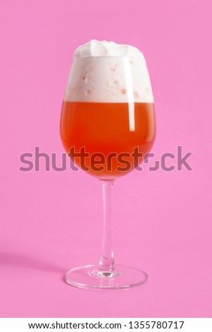 Glass of beer isolated on a pink background