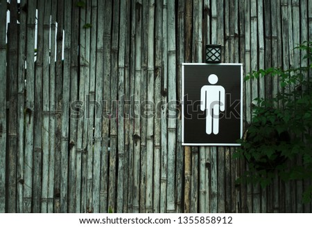 Restroom sign on a toilet door,on wood background.Toilet sign - Restroom Concept - black tone.WC / Toilet icons set. Men and women WC signs for restroom. 