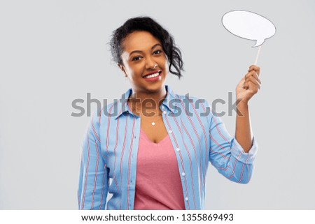 party props, photo booth and communication concept - happy african american young woman holding blank speech bubble over grey background Royalty-Free Stock Photo #1355869493