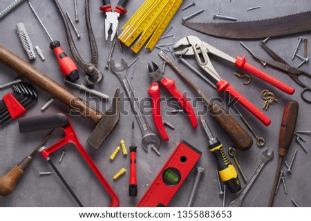 Variety of old vintage and modern household hand tools arranged as a flat lay still life on grey in a DIY and renovations concept Royalty-Free Stock Photo #1355883653