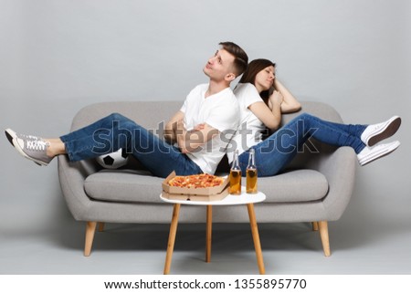 Boring sleeping couple woman man football fans cheer up support favorite team with soccer ball sitting back to back isolated on grey background. People emotions sport family leisure lifestyle concept