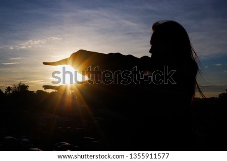The image of silhouette, a beautiful woman standing at the sun in the morning of the summer.