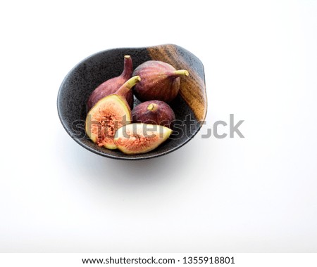 Organic figs in a bowl on white table background