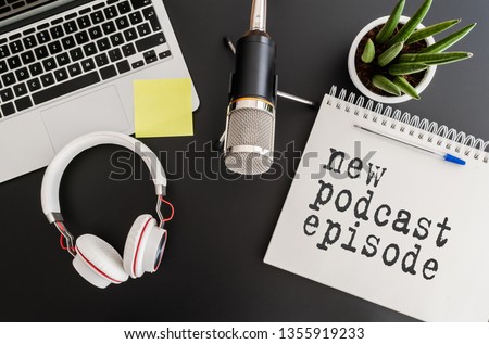 top view of podcast recording equipment on desk with words new podcast episode written on note pad Royalty-Free Stock Photo #1355919233