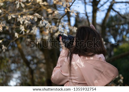 Beautiful woman photographer doing photos in a park