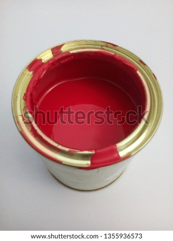 a tin containing red wood paint isolated from a white background