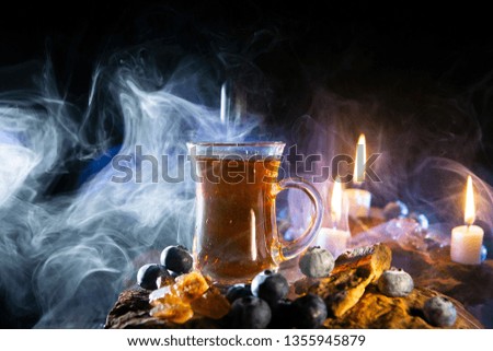 cup of tea in smoke and candles. Steam over a cup of tea.
