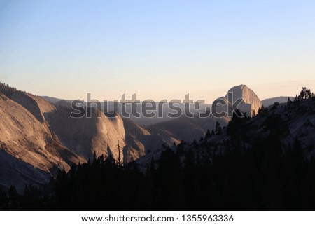 View of the mountain Half Dome and silhouettes of trees.