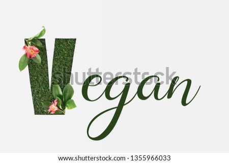 top view of green vegan lettering with leaves and alstromeria flowers isolated on white